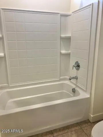 an empty room with a ceiling fan and window