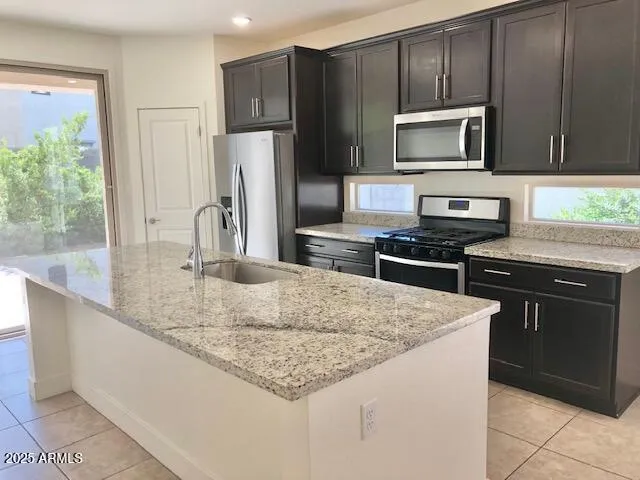 a kitchen with granite countertop a stainless steel stove and refrigerator