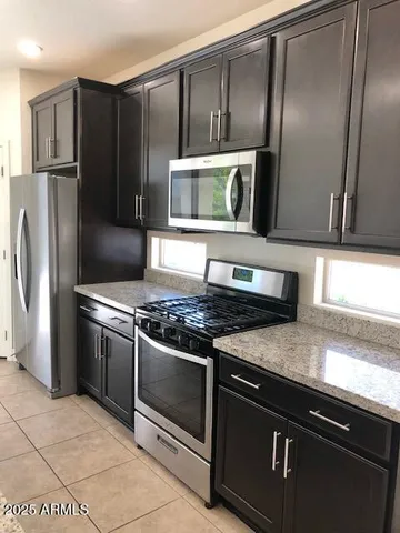 a kitchen with granite countertop a sink and a wooden cabinets