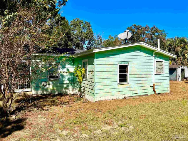 a yellow house with trees in front of it