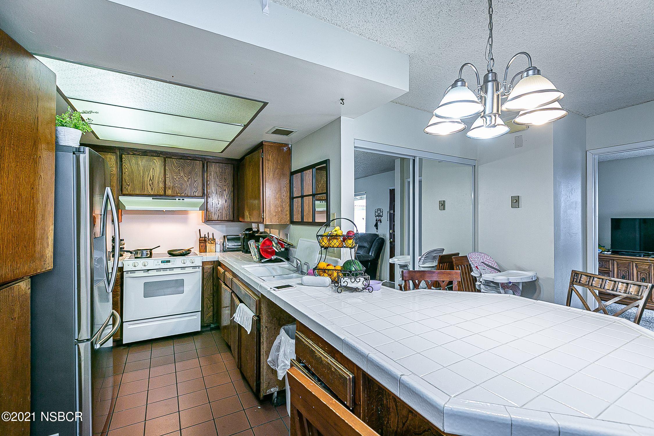 902 North O Street Lompoc, CA 93436 - Photo 9 of 25 a kitchen that has a lot of cabinets a sink and appliances in it