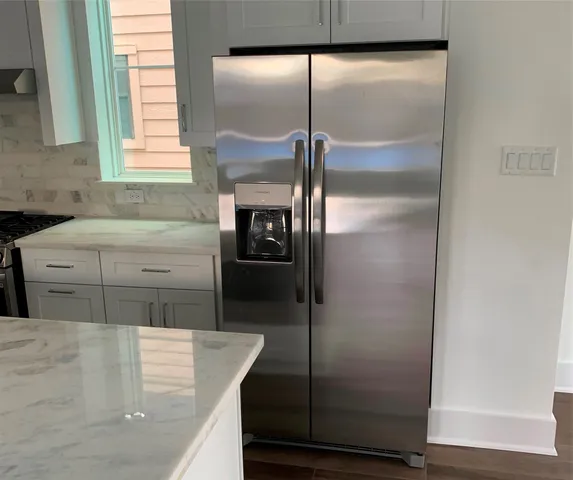 a kitchen with white cabinets and a glass door