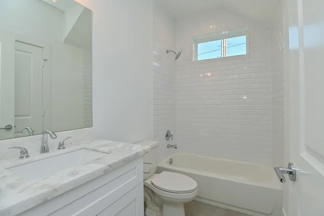 a bathroom with a granite countertop sink a toilet and shower