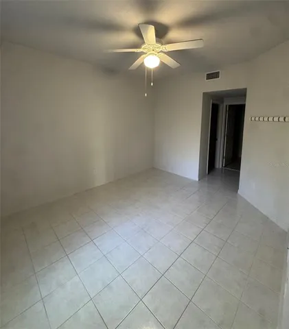 an empty room with a ceiling fan and window
