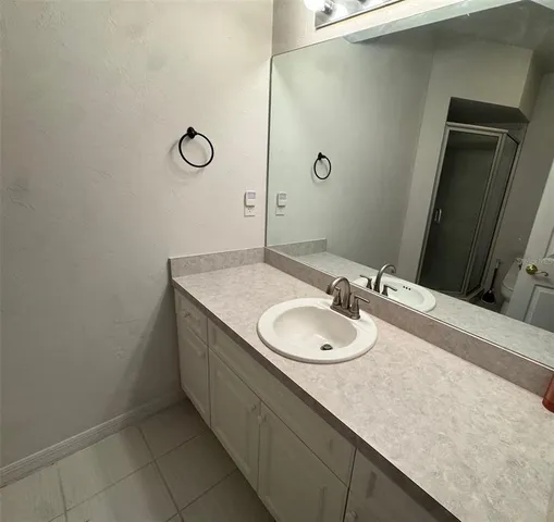 a bathroom with a granite countertop sink and a mirror
