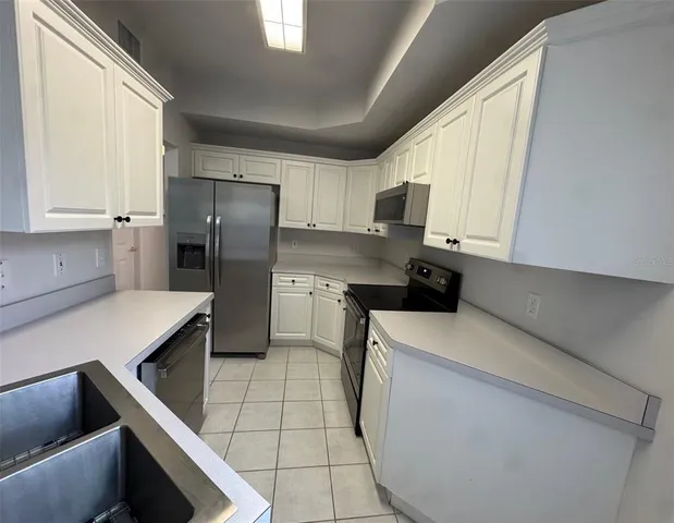 a kitchen with stainless steel appliances a refrigerator sink and cabinets