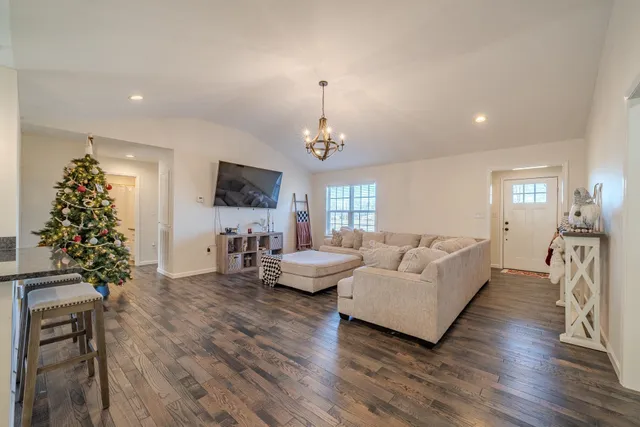 a living room with furniture chandelier and a flat screen tv