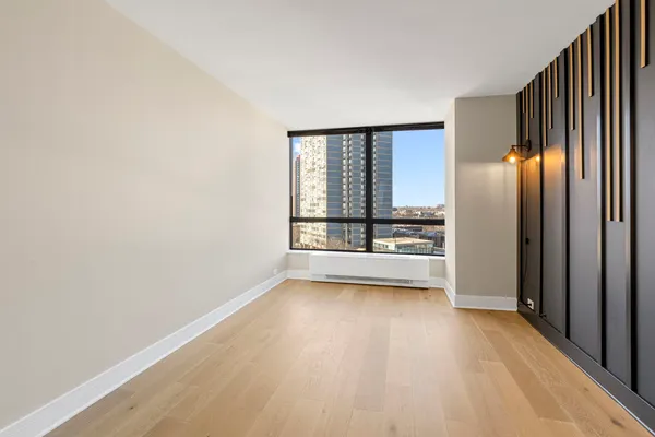 a view of a big room with wooden floor a ceiling fan