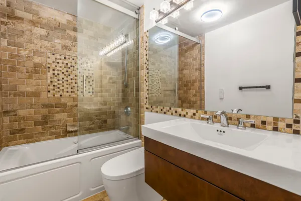 a bathroom with a sink a toilet and shower