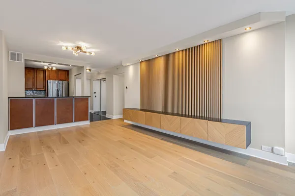a view of empty room with wooden floor