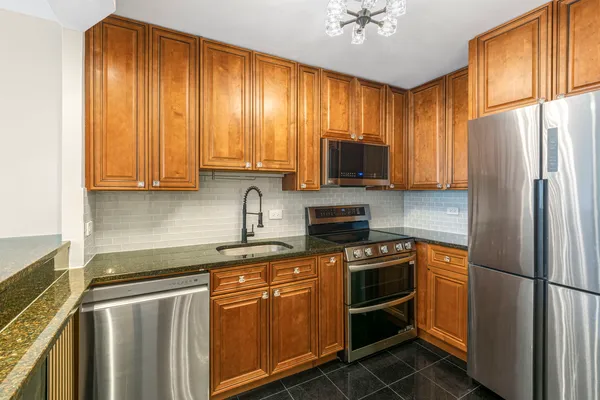 a kitchen with stainless steel appliances granite countertop a refrigerator stove microwave and sink