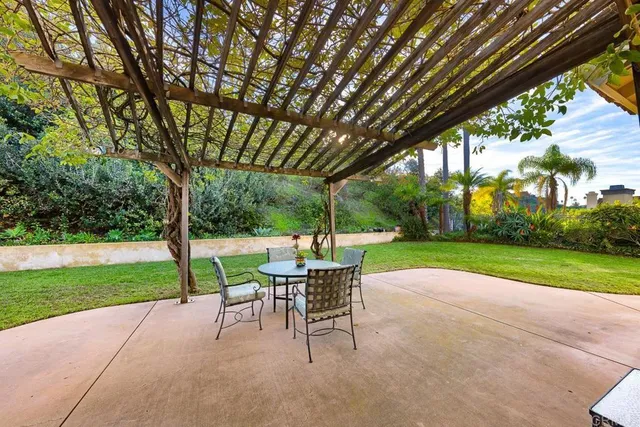 a view of a patio with a table chairs and a backyard
