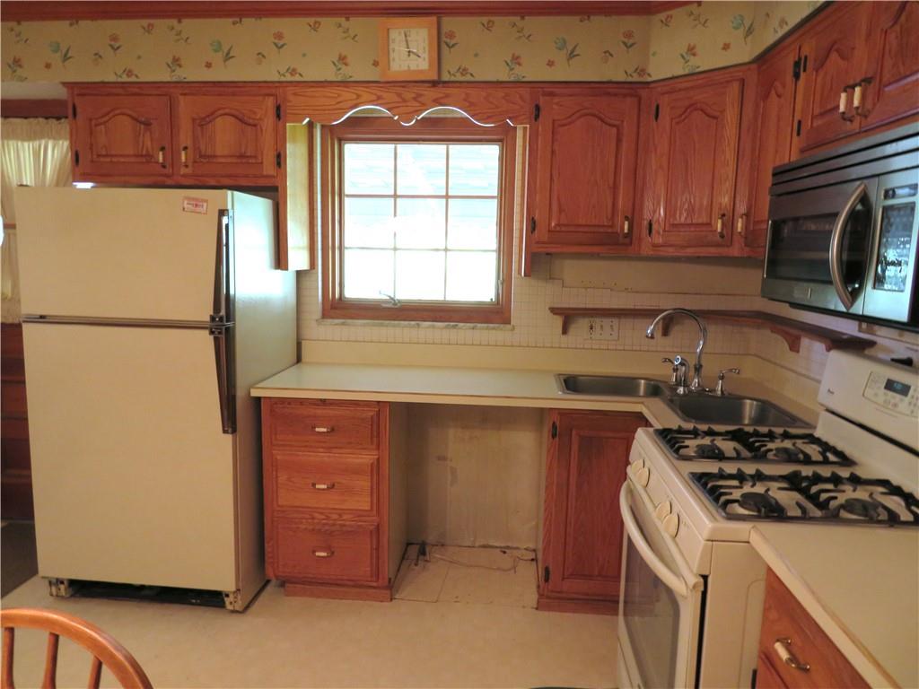736 Beaver Street Rochester, PA 15074 - Photo 9 of 24 a kitchen with a refrigerator a stove a microwave and cabinets
