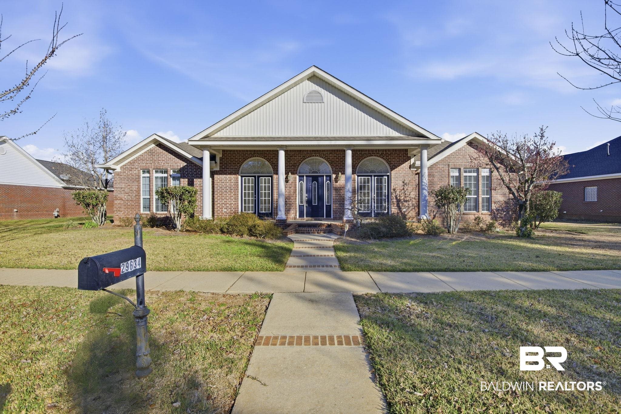 29634 St George Street Daphne, AL 36526 - Photo 1 of 47 Greek revival house featuring covered porch, a front yard, and brick siding