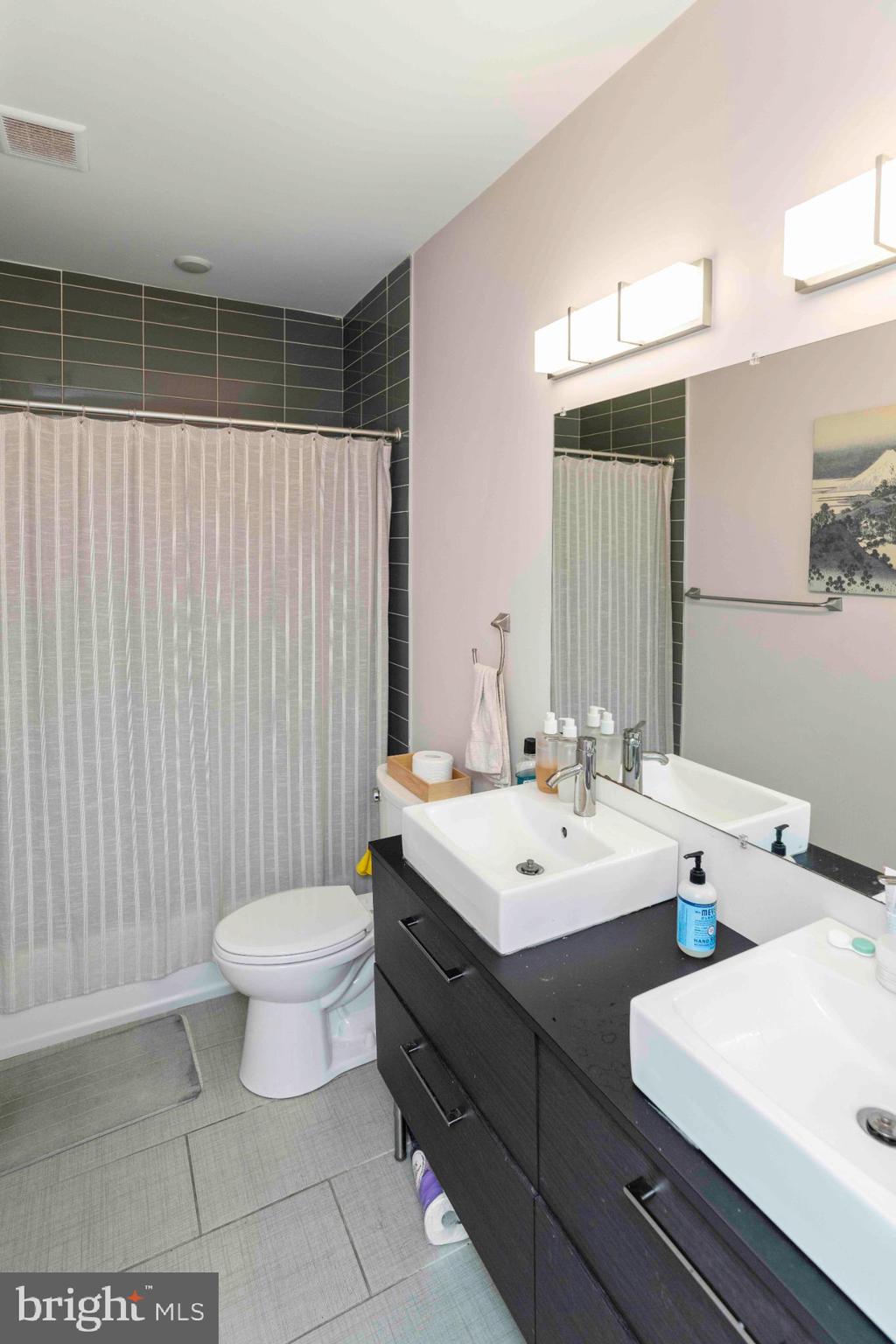 1309 South 20th Street Philadelphia, PA 19146 - Photo 30 of 37 a bathroom with a double vanity sink toilet and a mirror