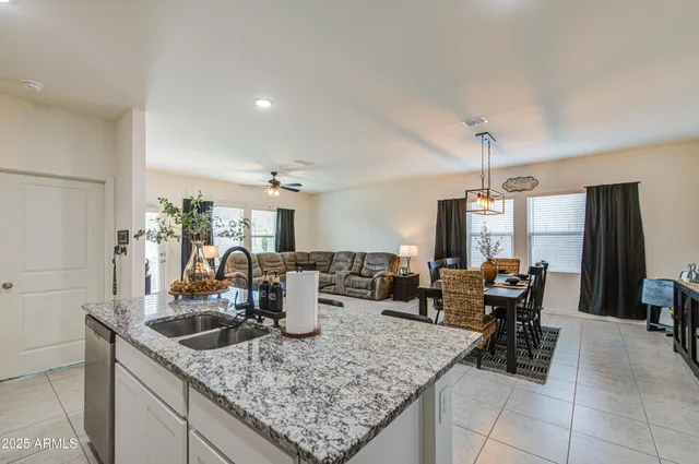 a view of a dining room and livingroom with furniture wooden floor a chandelier