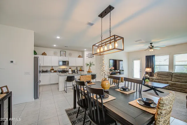 a view of a dining room and livingroom with furniture wooden floor a chandelier