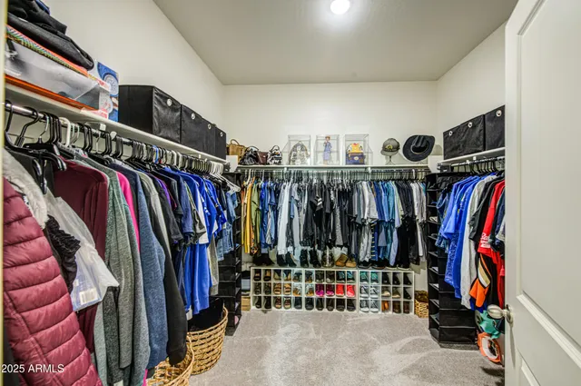 a view of walk in closet with clothes