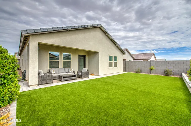 a backyard of a house with table and chairs and plants
