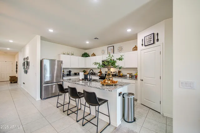 a kitchen with refrigerator and chairs