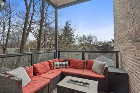 a balcony with wooden floor and outdoor seating