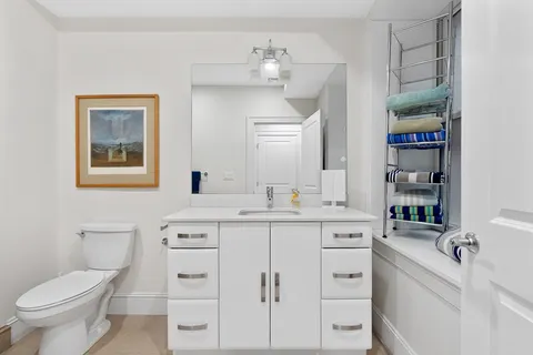 a bathroom with a sink a toilet and a mirror
