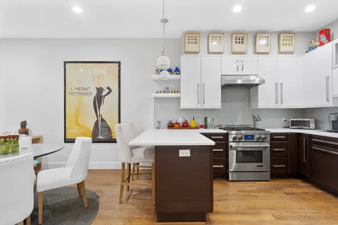 a kitchen with kitchen island a stove a sink and a refrigerator