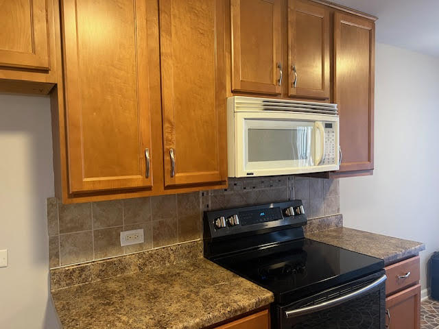711 South River Road, Unit 511 Des Plaines, IL 60016 - Photo 12 of 23 a kitchen with granite countertop cabinets and black appliances
