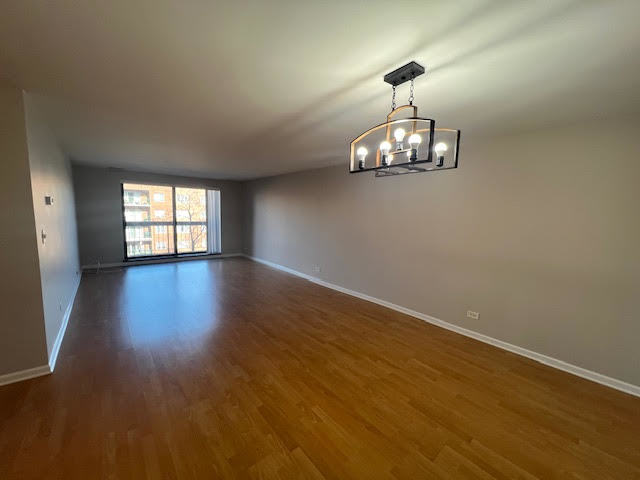 711 South River Road, Unit 511 Des Plaines, IL 60016 - Photo 5 of 23 an empty room with wooden floor and windows