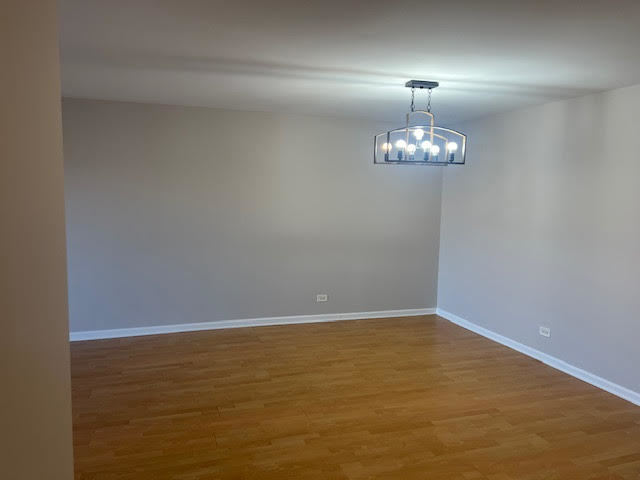 711 South River Road, Unit 511 Des Plaines, IL 60016 - Photo 7 of 23 a view of wooden floor and chandelier in a room
