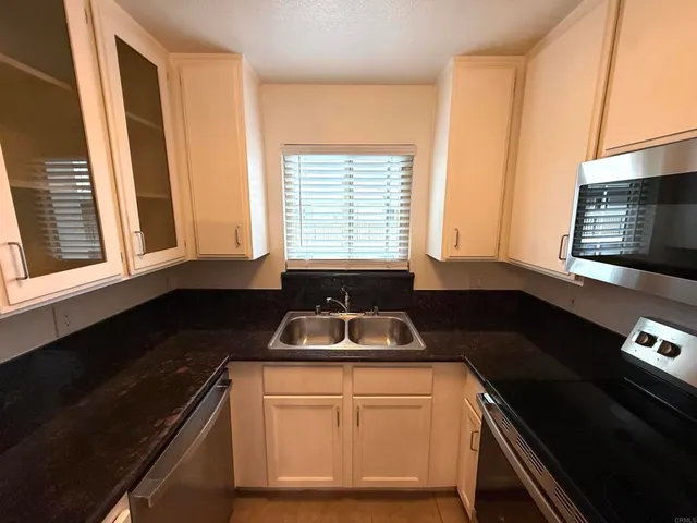 a kitchen with a sink a stove and a microwave