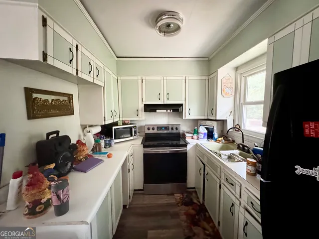 a kitchen with a sink appliances and cabinets