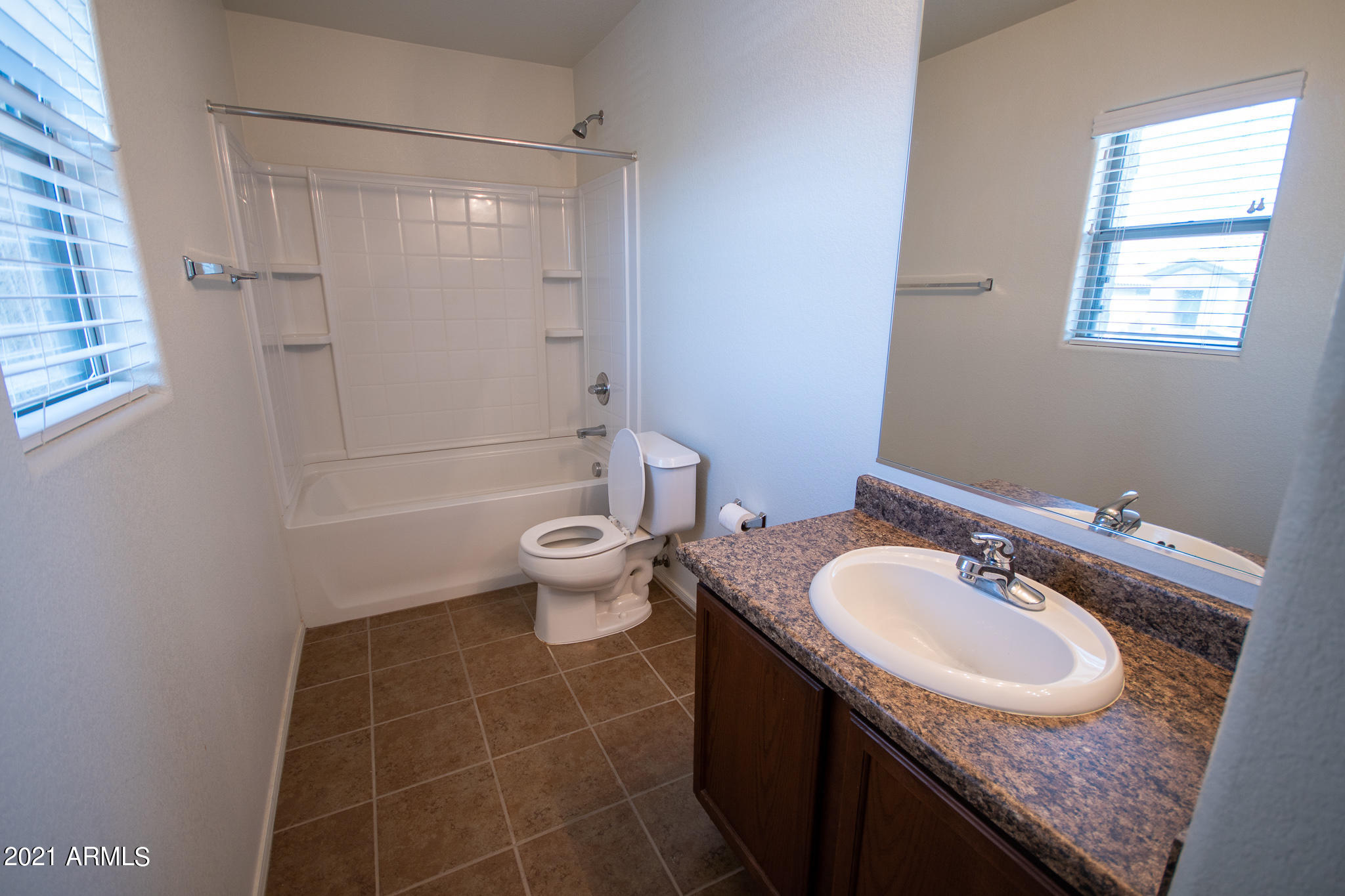 6433 West Harwell Road Laveen, AZ 85339 - Photo 13 of 18 a bathroom with a granite countertop sink a toilet and shower