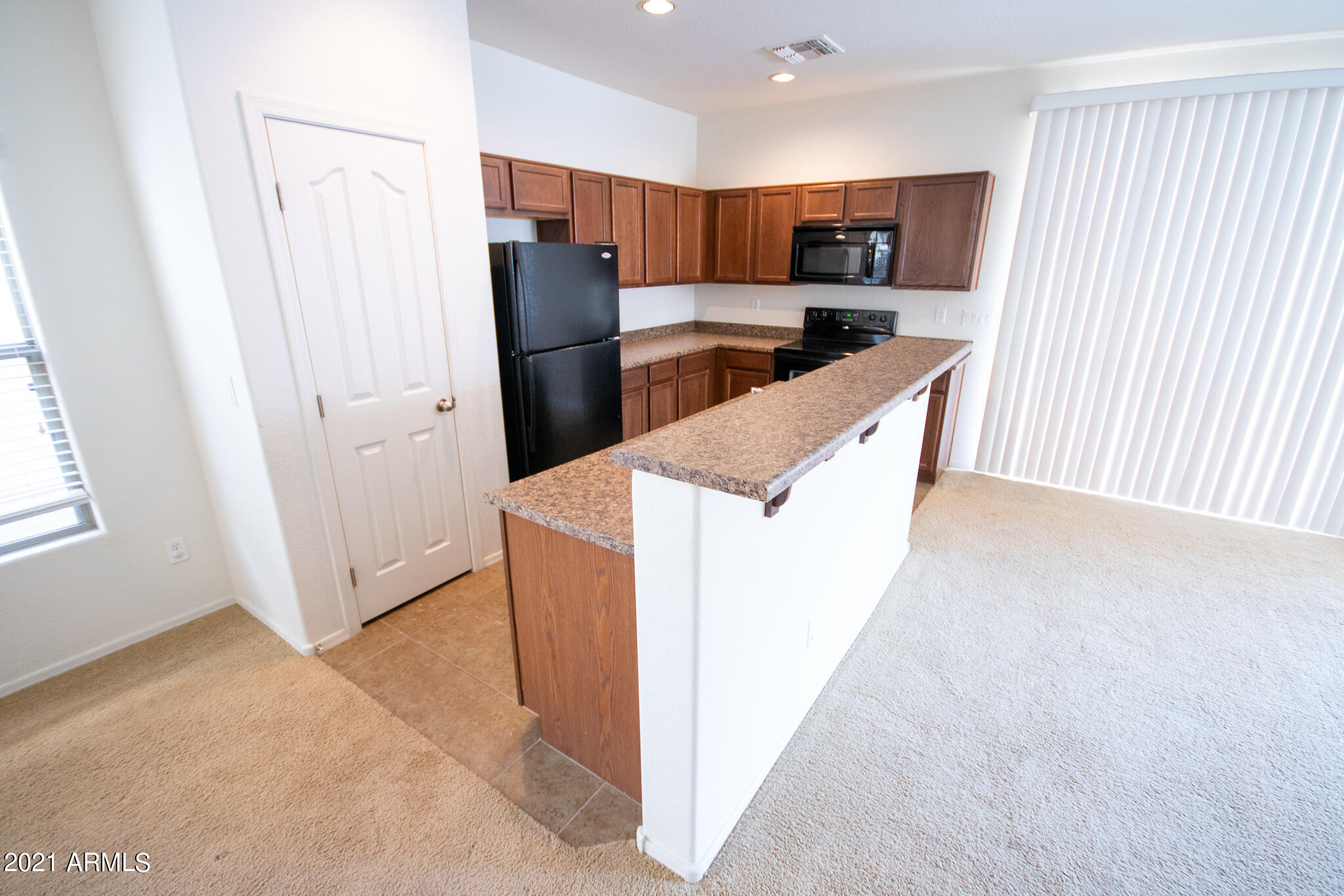 6433 West Harwell Road Laveen, AZ 85339 - Photo 3 of 18 a kitchen with refrigerator cabinets and wooden floor