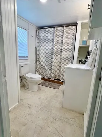 a bathroom with a toilet a sink and a window