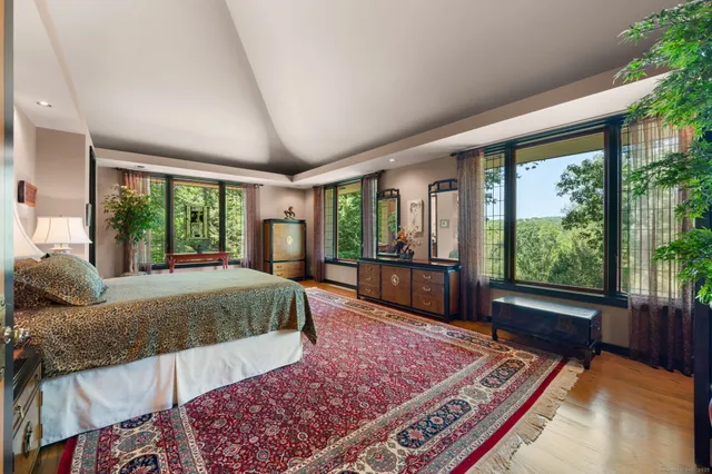 a bed sitting in a spacious bedroom next to a window