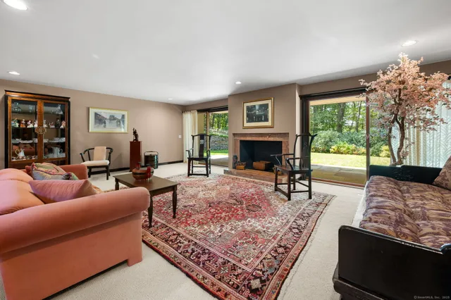 a living room with furniture large window and a fireplace