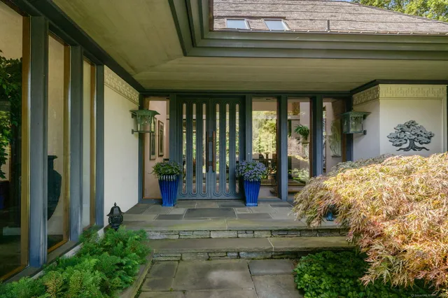 a view of yellow house with potted plants