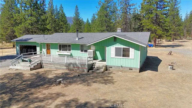 a aerial view of a house with a yard and trees