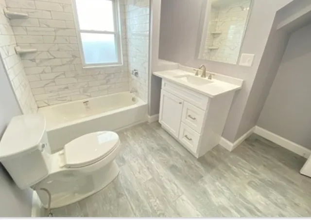 a spacious bathroom with a double vanity sink a toilet and bathtub