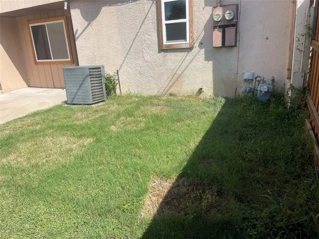 a backyard of a house with lawn chairs and wooden fence