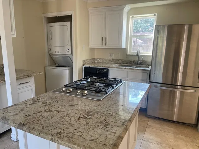 a kitchen with granite countertop white cabinets and a stove