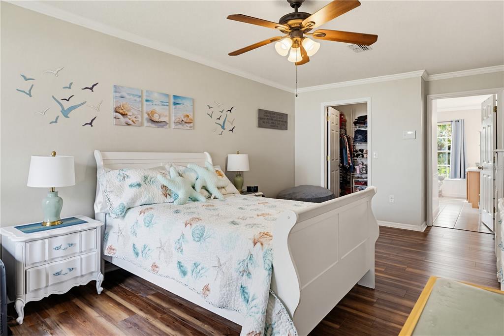 3497 Chadwick Avenue Spring Hill, FL 34609 - Photo 23 of 47 a bedroom with a large bed and a chandelier