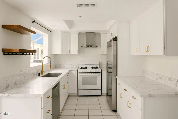 a kitchen with stainless steel appliances granite countertop a sink stove and refrigerator