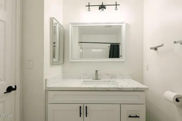 a bathroom with a granite countertop sink and a mirror