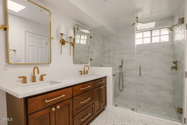 a bathroom with a shower sink vanity and mirror