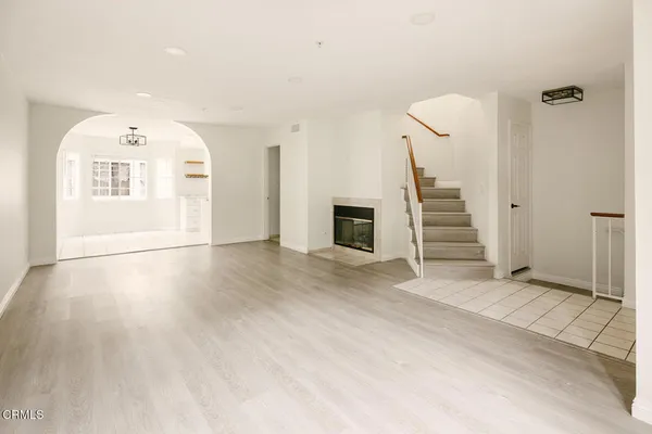 a view of a livingroom with wooden floor and staircase