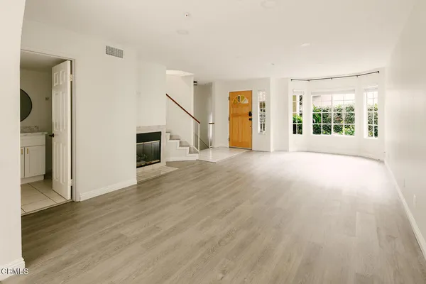 a view of a big room with wooden floor staircase and windows