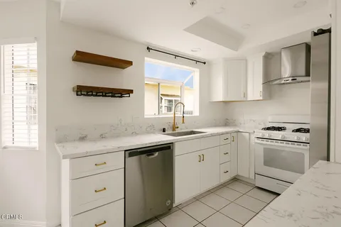 a kitchen with white cabinets and appliances