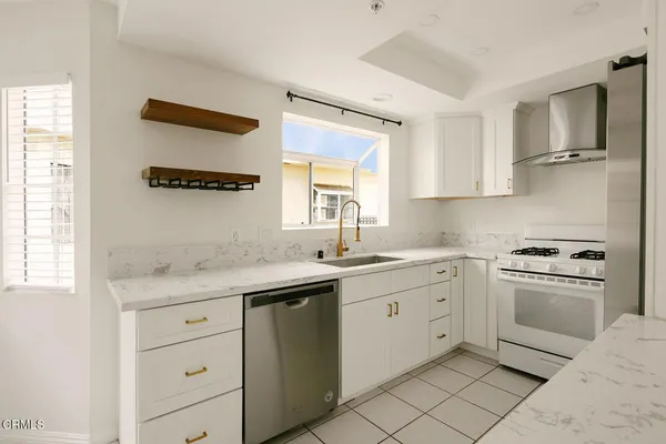 a kitchen with white cabinets and appliances